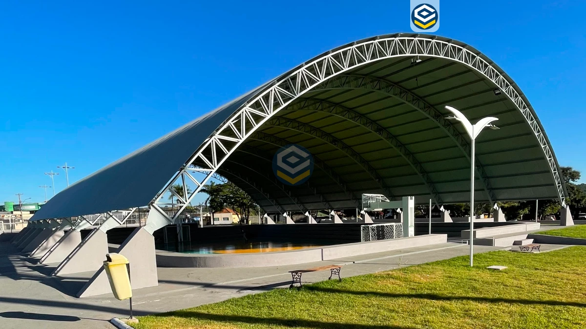 Galpão metálico arqueado sobre uma quadra esportiva, construção eficiente que maximiza a economia e a durabilidade estrutural.