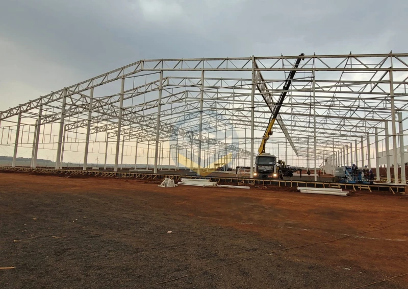 Estrutura metálica de grande porte para galpão industrial em execução dentro de complexo fabril.