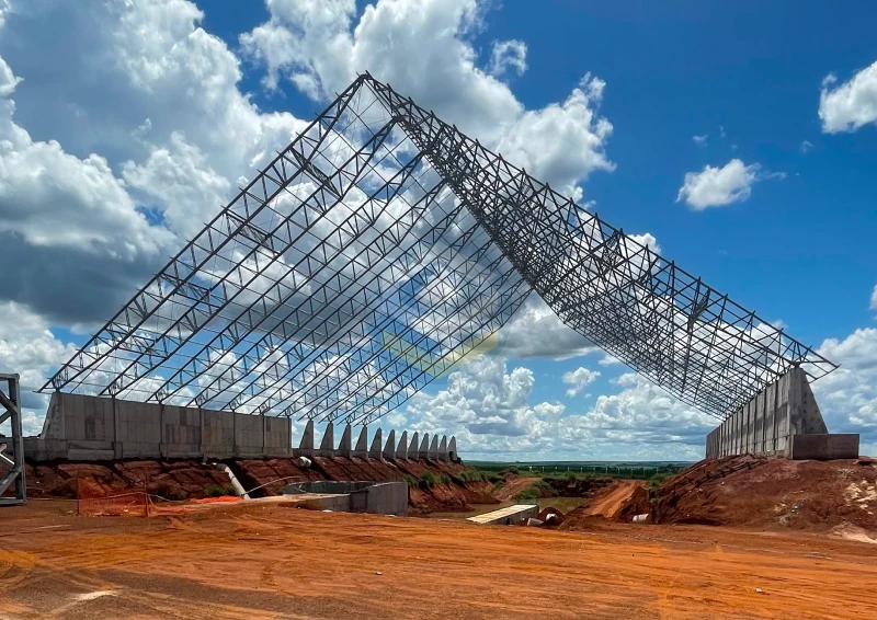 Estrutura metálica tipo graneleiro com tesoura em V, em montagem para cobertura industrial.
