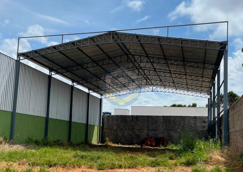 Galpão metálico 12x25m com pilares acoplados, tesoura treliçada de duas águas e banzo inferior arqueado.