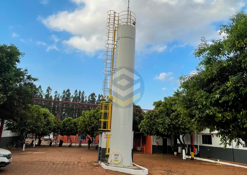 Reservatório metálico cilíndrico tubular de 15 mil litros com escada marinheiro, corrimão e linha de vida instalado em indústria.